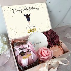 congratulations gift box with personalized items in it and flowers on the table next to it