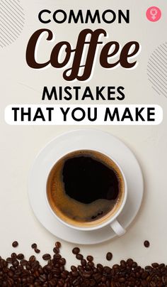 a cup of coffee sitting on top of a white table next to some coffee beans