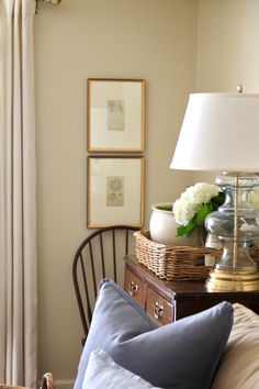 a bedroom with a bed, lamp and pictures on the wall