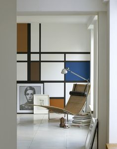 a chair sitting in front of a wall with pictures on it