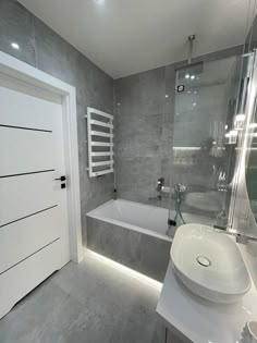 a white sink sitting next to a bath tub in a bathroom