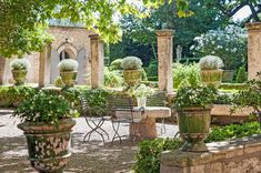 an outdoor dining area with tables and chairs, surrounded by greenery in the background