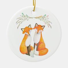 two foxes sitting next to each other on a white ornament