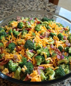 a glass bowl filled with broccoli and cheese