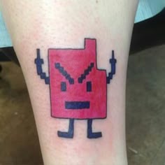 a cartoon character is on the leg of a person with a tattoo that looks like an old school computer gameboy