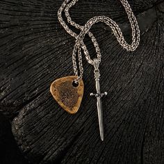 A manifestation of menswear designer John Varvatos' rock'n'roll inspired ethos, the BRASS GUITAR PICK Necklace for Men is pure style. The rustic solid brass guitar pick pendant is etched with a fingerprint design and strung on a sterling silver oval link chain, complete with a signature John Varvatos skull clasp. Rock out in luxury style with the Brass Guitar Pick Pendant Chain for Men. Size: 1 inch long and 1 1/4 inches wide. Chain Size: 24 inches long and 1/8 thick. Material: Brass. 925 Sterli Fingerprint Design, Guitar Pick Jewelry, Pick Necklace, Mens Designer Jewelry, Guitar Pick Necklace, Rock'n Roll, John Varvatos, Mens Pendant, Necklace For Men