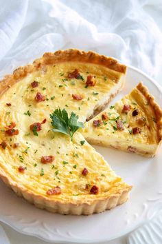 a quiche on a plate with one slice missing