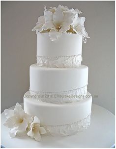 a white wedding cake with flowers on top