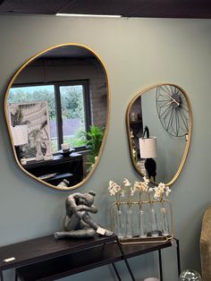 two mirrors on the wall above a table