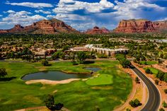 an aerial view of a golf course with mountains in the background