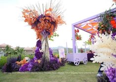 an arrangement of flowers on display at a wedding ceremony in the grass with a cart behind it