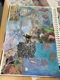 an open notebook with many different things on the pages and in front of it is a flower