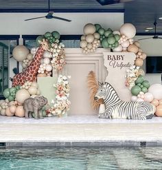 a baby shower is decorated with balloons and giraffes