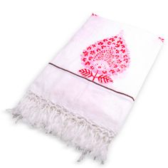 a red and white towel with fringes on the bottom that has an image of a tree