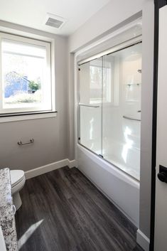 a bathroom with wood flooring and white walls