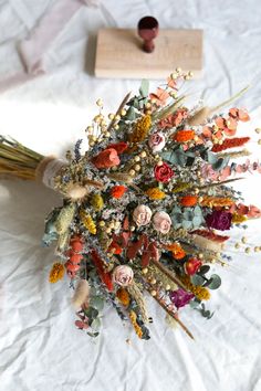 an arrangement of dried flowers on a white sheet