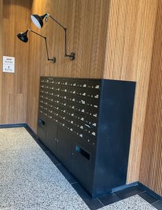 a large mailbox sitting in the corner of a room next to a wall lamp