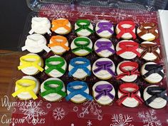 cupcakes decorated with colorful bow ties and snowflakes are in a box