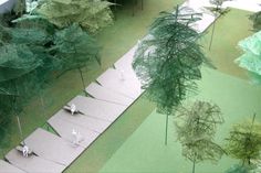 an aerial view of trees and stairs in a miniature forest setting with people walking down the path