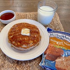 a plate topped with pancakes next to a glass of milk