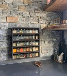 a kitchen with stone walls and shelves filled with spices