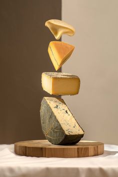 a stack of cheese on top of a wooden cutting board