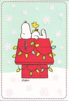 a snoopy christmas card with a dog on top of a present box in the snow