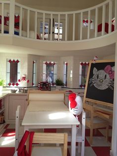 a kitchen with a table, chairs and a cat in the hat sign on the wall