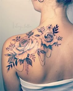 a woman's back shoulder tattoo with roses on it