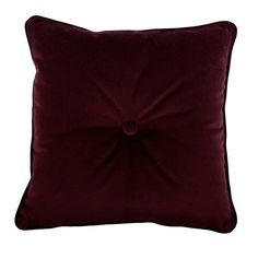 a dark red velvet pillow on a white background