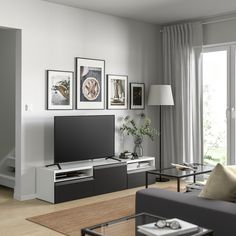 a living room filled with furniture and a flat screen tv on top of a entertainment center