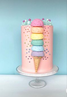 a pink cake with ice cream cones on top