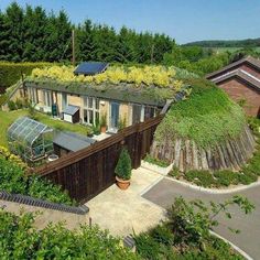 an aerial view of a house with a green roof and plants growing on the roof