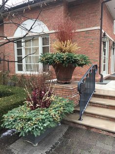 two large planters on the side of a brick building with steps leading up to them