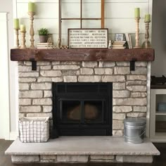 a fireplace with some candles and other items on top of it, in a living room