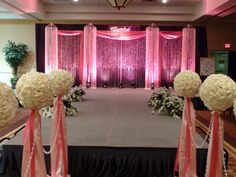 the stage is decorated with pink and white flowers