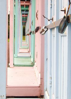 there are many different colored doors and locks on the building's exterior walls that lead to an alley way