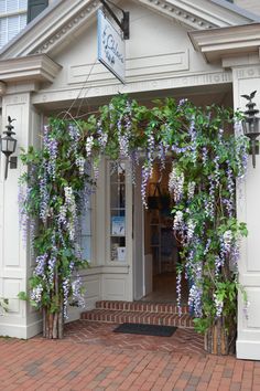 an entrance to a store with purple flowers on it