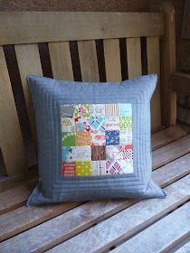 a patchwork pillow sitting on top of a wooden bench