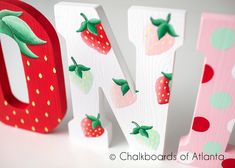 the letters are decorated with strawberrys and polka dots