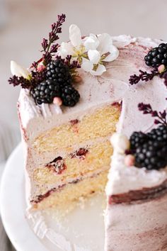 a cake with white frosting and blackberries on top