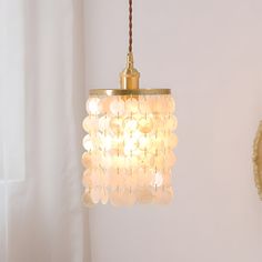 a chandelier hanging from a ceiling in a room with white walls and curtains