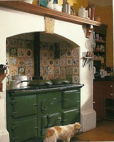 a dog is standing in front of an old fashioned stove with its head on the floor