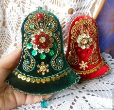 there are two small christmas hats on the lace doily, one is red and one is green