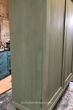 an armoire painted green in a room