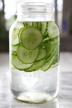 a mason jar filled with cucumber slices and mint