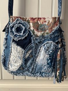 a purse made out of old jeans is hanging on a door handle with lace and fabric