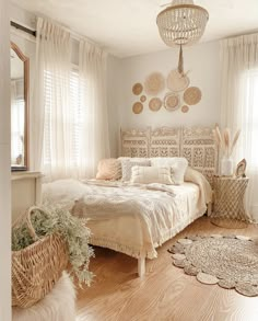 a bed room with a neatly made bed next to two baskets on the floor and windows