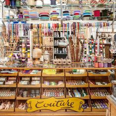 the inside of a store with lots of items on shelves and in front of it