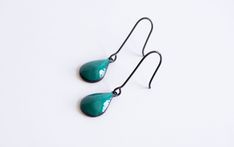 Experience the allure of our spruce drop dangle earrings—a captivating addition that elevates your jewelry collection. With their sleek raindrop-shaped design adorned in vibrant blue-green enamel, these earrings exude a unique and eye-catching aesthetic. The striking turquoise hue beautifully contrasts against the blackened silver ear wires, creating a distinctive look. Crafted with durability in mind, these earrings not only possess stunning visual appeal but also promise long-lasting charm. Th Green Nickel-free Teardrop Drop Earrings, Green Nickel-free Teardrop Earrings, Green Teardrop Drop Earrings Nickel Free, Modern Green Drop Jewelry, Minimalist Green Teardrop Earrings, Hypoallergenic Green Enamel Jewelry, Green Modern Teardrop Jewelry, Green Teardrop Enamel Jewelry, Black Enamel Teardrop Earrings For Gift